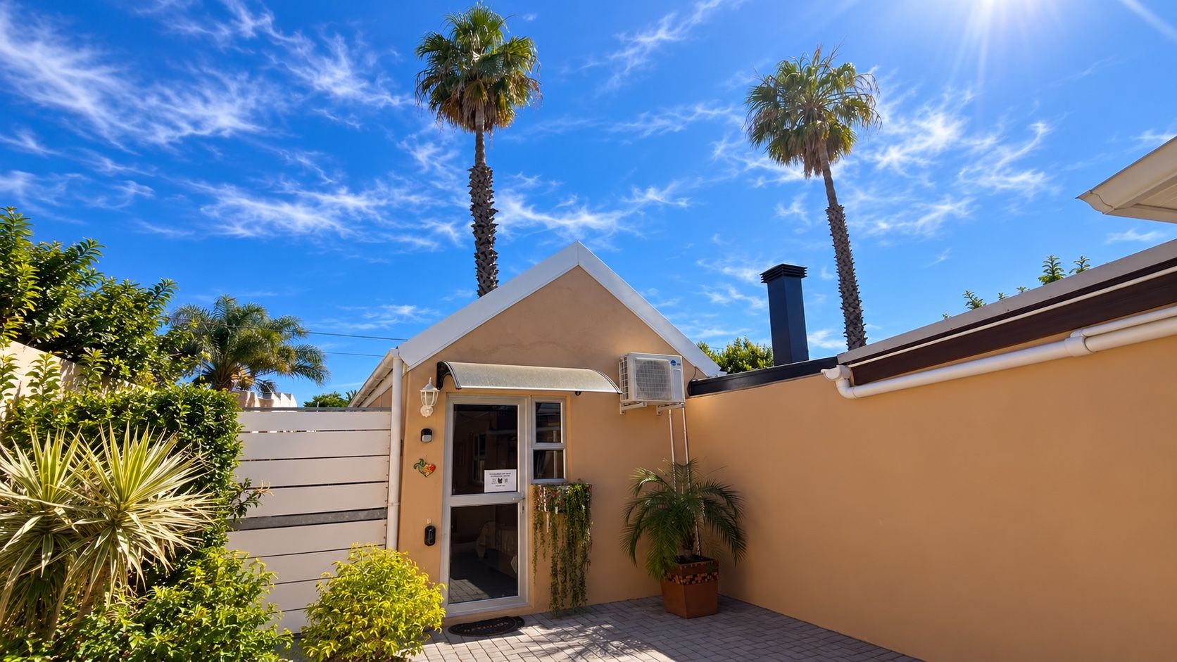 Boston Twin Palms self-catering accommodation in Bellville, featuring two tall palm trees above the private entrance.